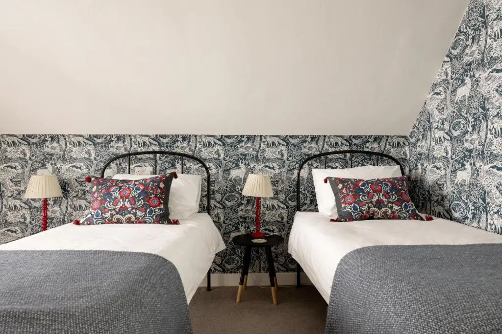two beds sitting next to each other in a bedroom at Kirktoun Cottage in Duffus