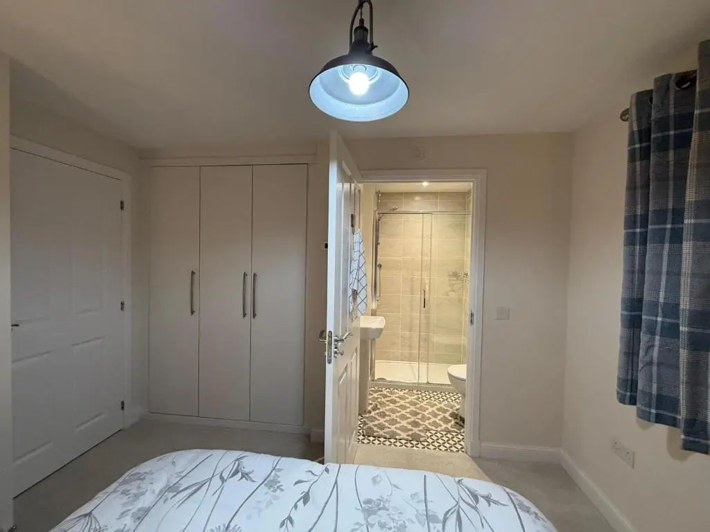 a bedroom with a bed and a bathroom with a shower at Loch Ness Hideaway in Inverness
