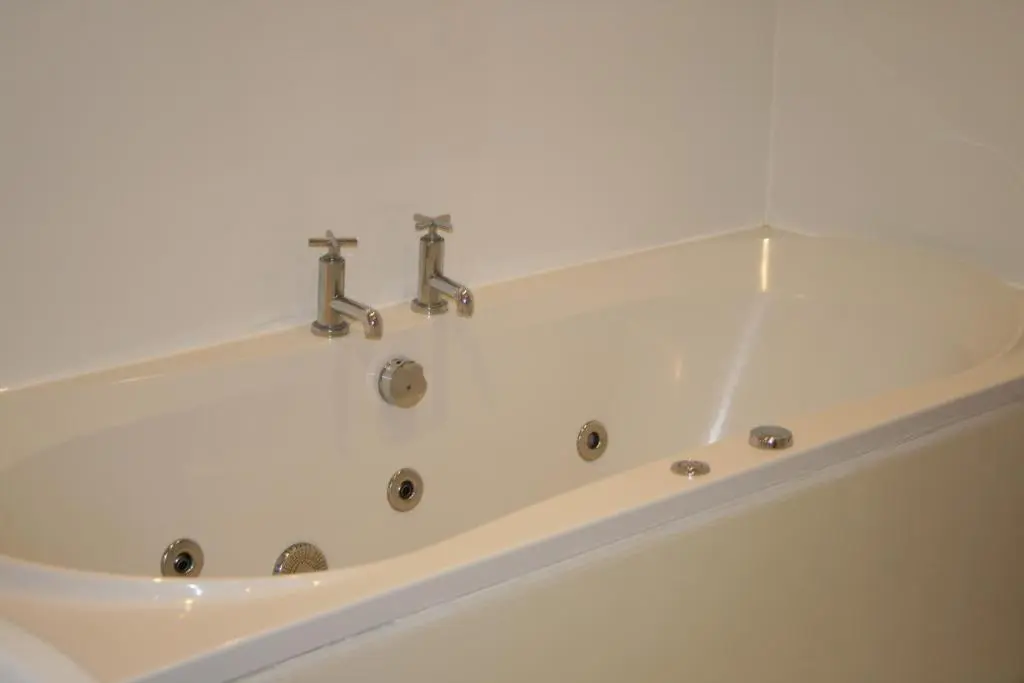 a white bath tub with two faucets on it at BCC Loch Ness Cottages in Drumnadrochit