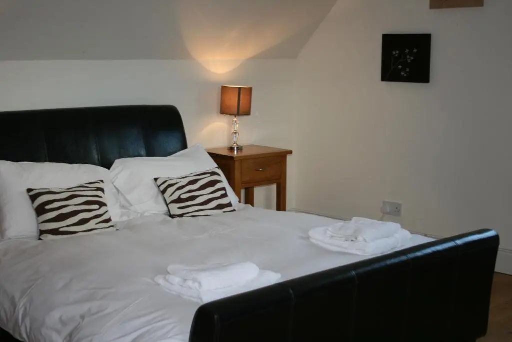 a bed with two towels on top of it at BCC Loch Ness Cottages in Drumnadrochit
