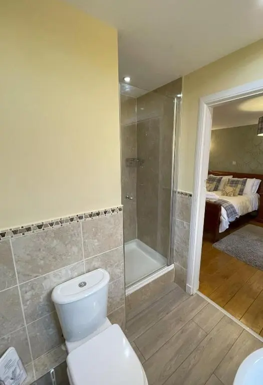 a bathroom with a toilet and a walk in shower at Groose Hoose in Glenshee
