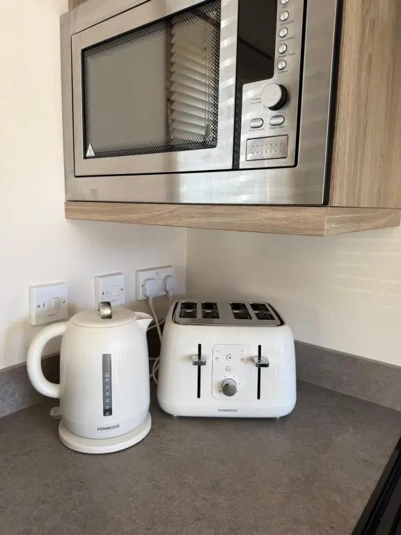 a microwave and a toaster sitting on a kitchen counter at Agnes Place in Nairn