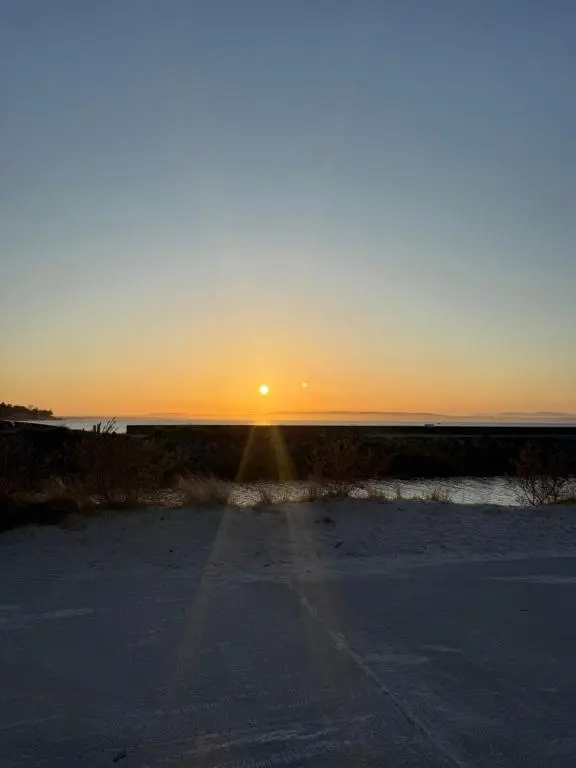 a sunset over a road with the sun in the distance at Agnes Place in Nairn