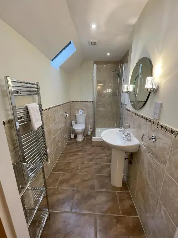 a bathroom with a sink and a shower and a toilet at Coo Shed in Glenshee