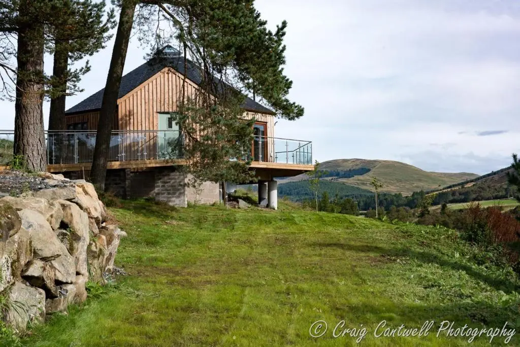 a house on the side of a hill at Scots Pine Treehouse in Glenshee