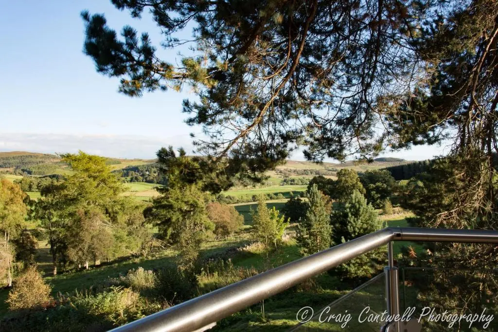 a view of the valley from the balcony of the house at Scots Pine Treehouse in Glenshee