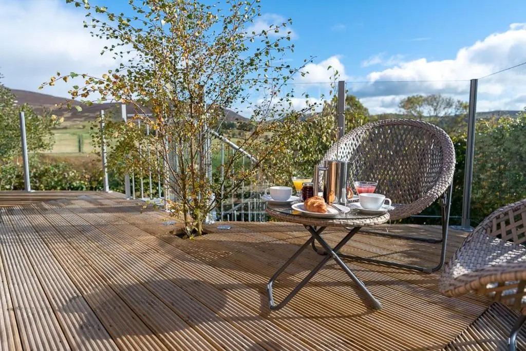 a table with a tray of food on a patio at Silver Birch Treehouse in Glenshee
