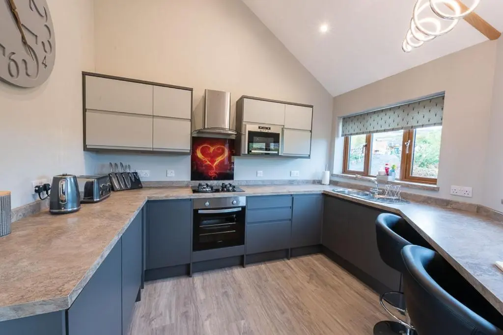 a kitchen with blue cabinets and a counter top at Silver Birch Treehouse in Glenshee