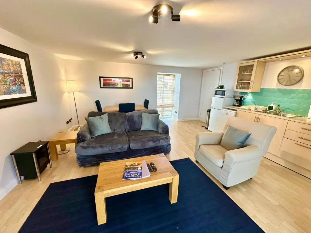 a living room with a couch and a table at Dolphin Bay Suites in Ardersier
