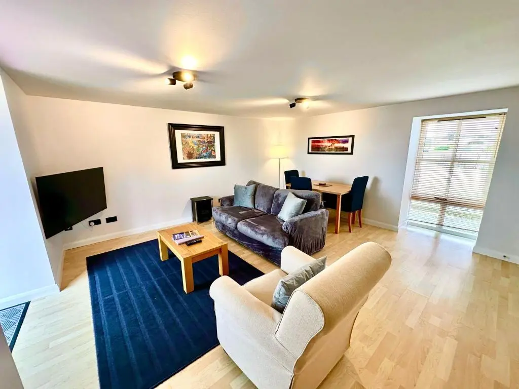 a living room with a couch and a table at Dolphin Bay Suites in Ardersier