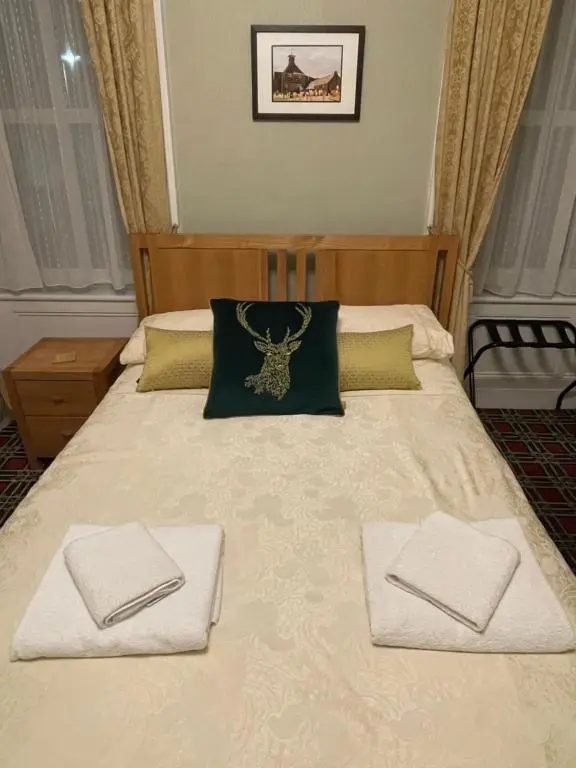 a bed with two white towels on top of it at Stag and Barrel in Elgin