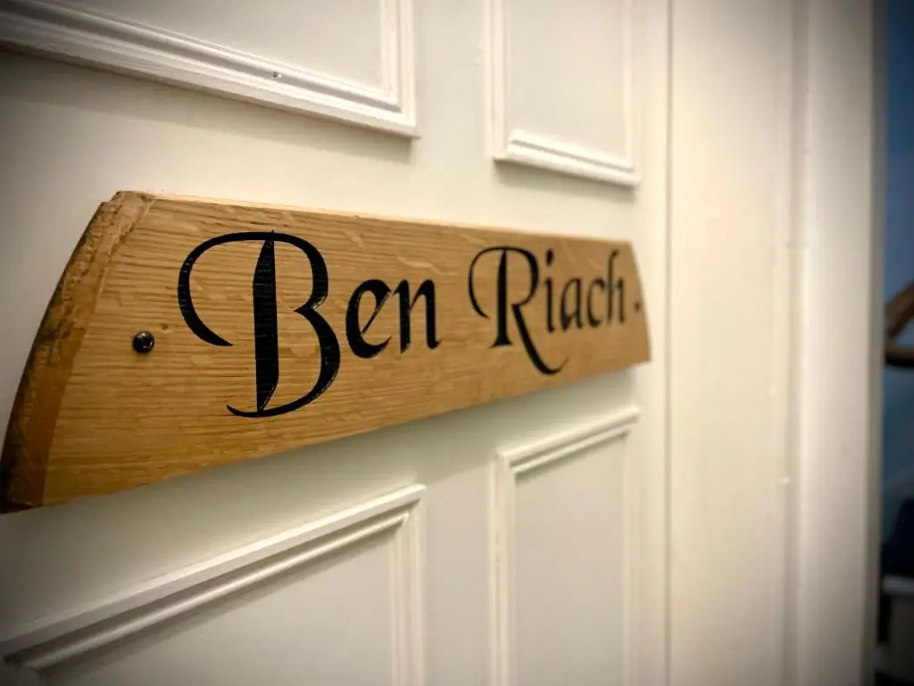 a wooden sign on a door with the words ben ragnar at Stag and Barrel in Elgin