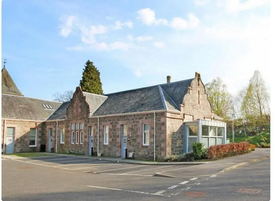 a large brick building with a parking lot at Mercury Holiday Home 1 Bedroom 7 Westercraigs Apartment -Free Parking in Inverness