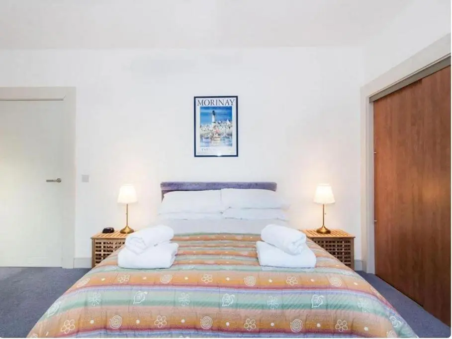 a bedroom with a large bed with two lamps at Mercury Holiday Home 1 Bedroom 7 Westercraigs Apartment -Free Parking in Inverness