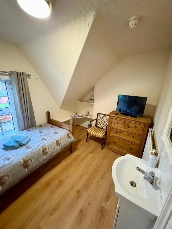 a bedroom with a bed and a sink and a bathroom at Ythanview Hotel