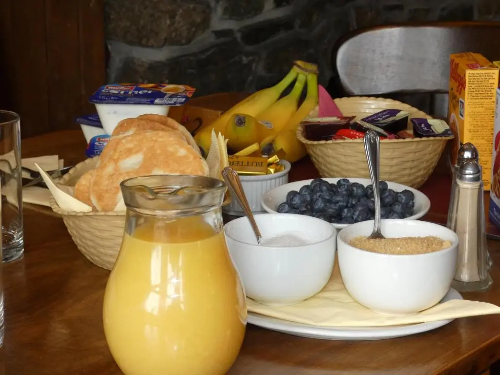 a table with a plate of bread and a jug of orange juice at Ythanview Hotel