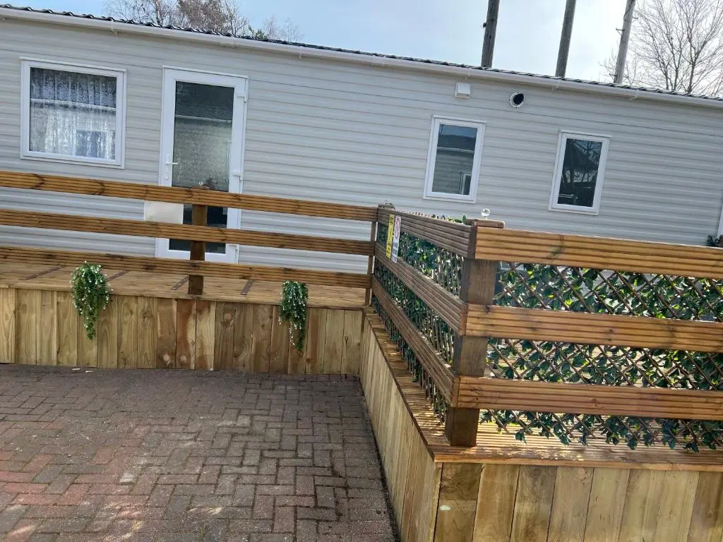 a wooden fence in front of a house at The Highland Getaway 43 in Boat of Garten