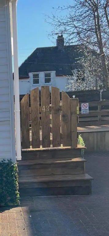 a wooden bench sitting in front of a house at The Highland Getaway 43 in Boat of Garten