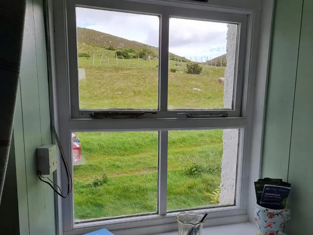 a window with a view of a field of grass at Strathnoon in Inverness