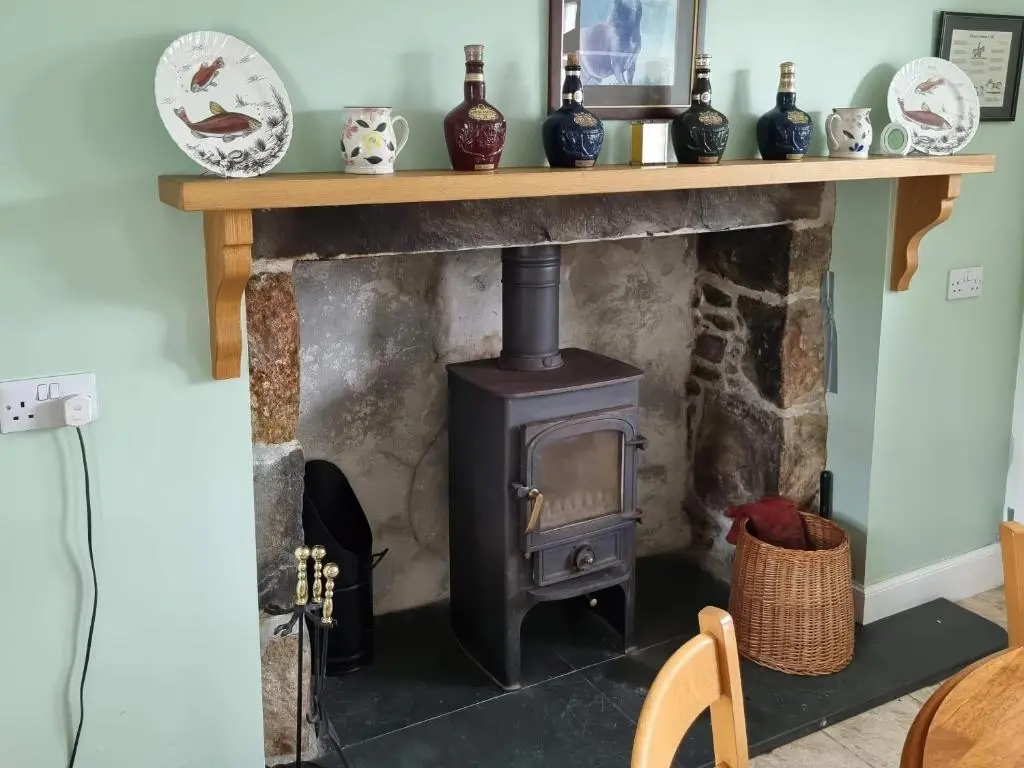 a fireplace with a wood stove in a room at Strathnoon in Inverness