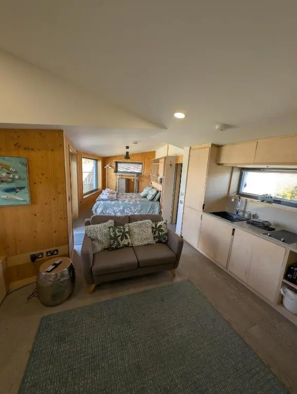 a living room with a bed and a couch at Modern Eco-Lodges near Findhorn Beach in Findhorn