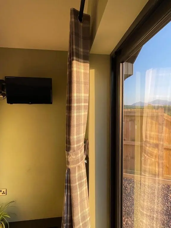 a curtain in a room with a window at The Wee Knoll in Invergarry