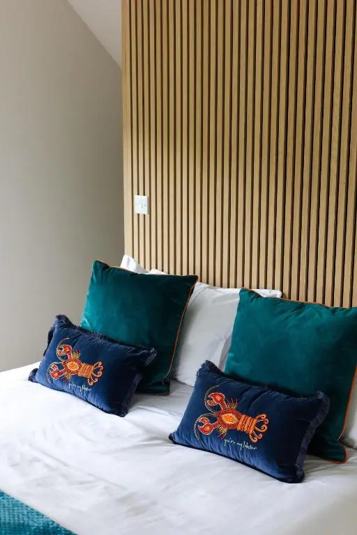 a bed with four blue pillows on top of it at Caledonian View House in Dalneigh