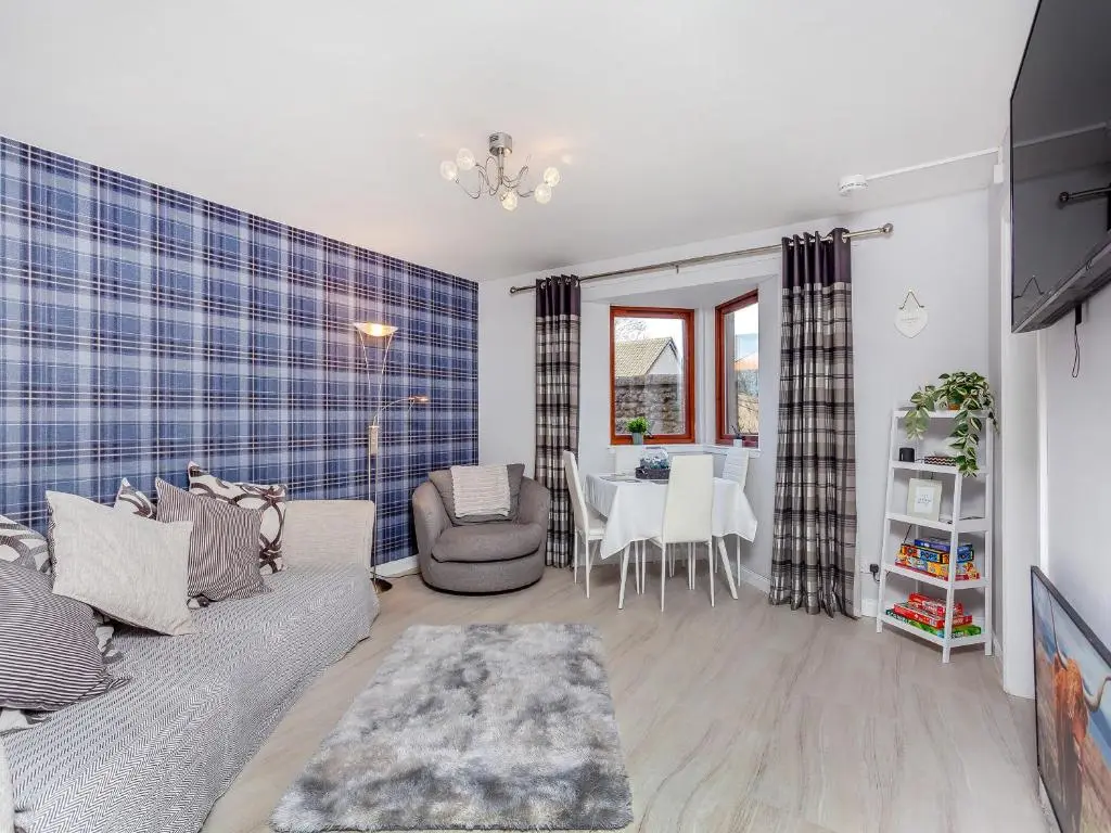 a living room with a couch and a table at Failte Luxury Apartment in Inverness