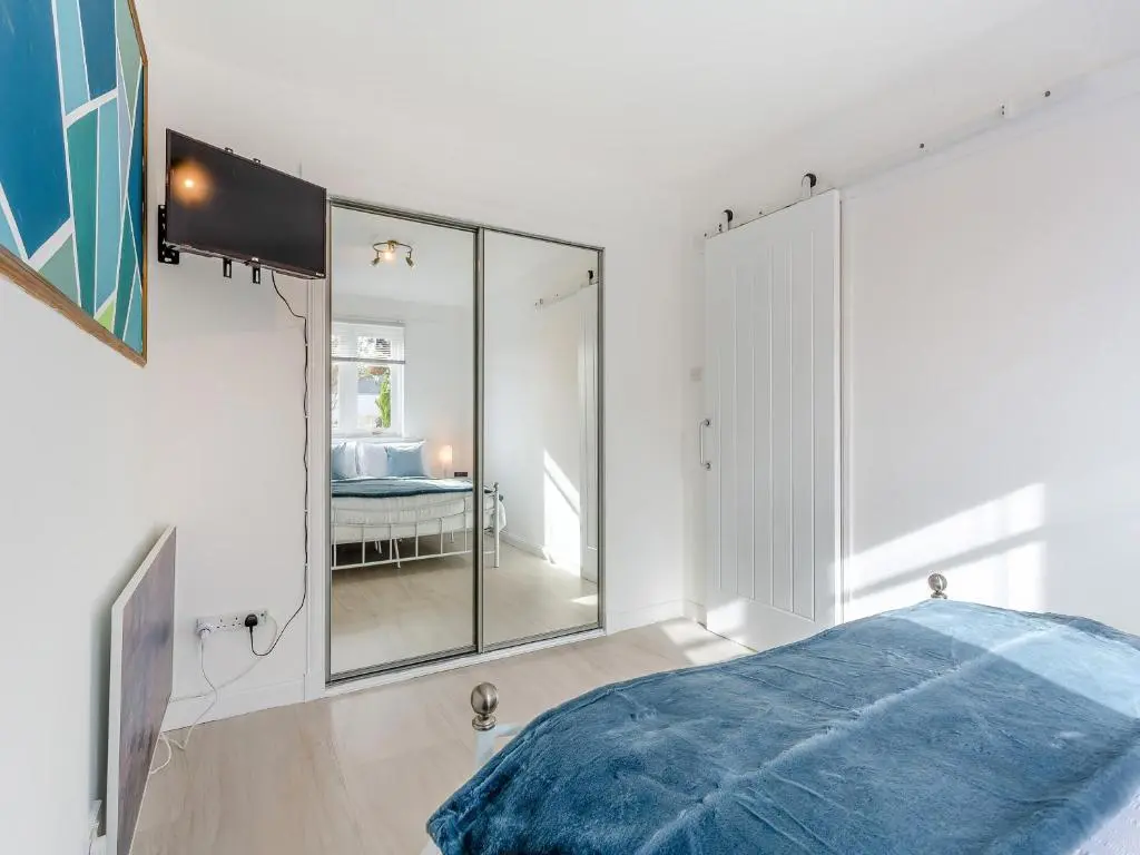 a bedroom with a large mirror and a bed at Failte Luxury Apartment in Inverness