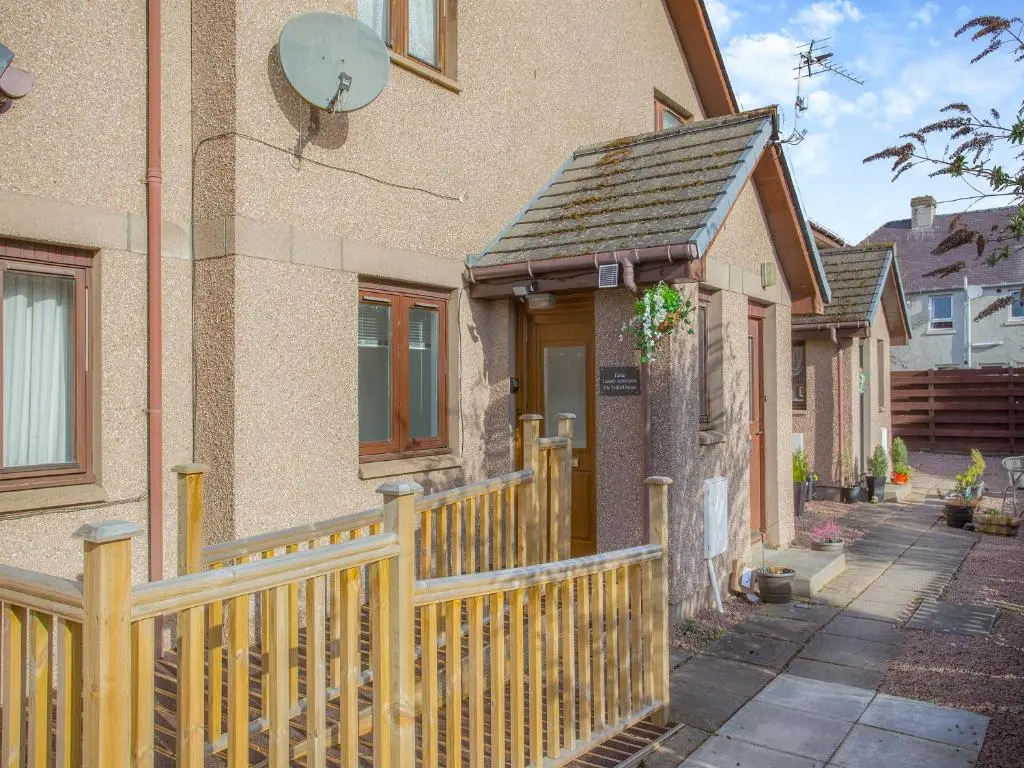 a wooden fence in front of a house at Failte Luxury Apartment in Inverness