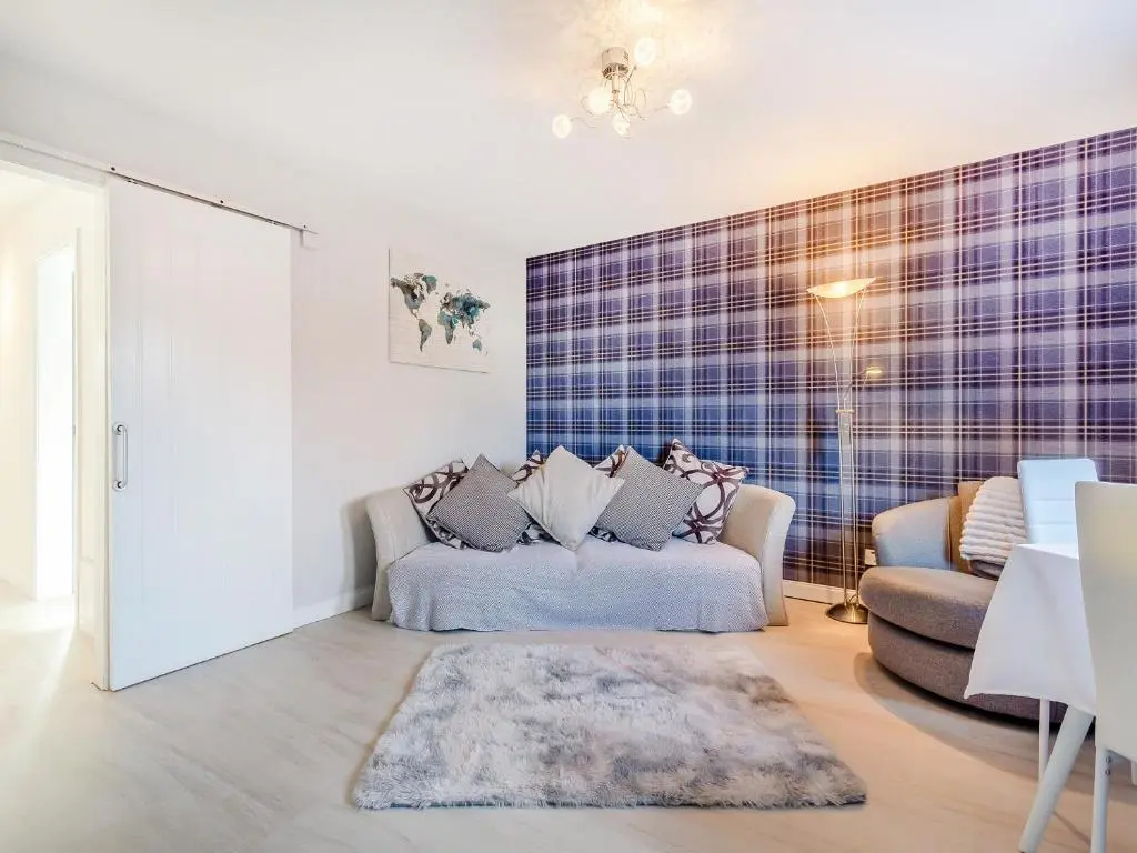 a living room with a couch and a chair at Failte Luxury Apartment in Inverness
