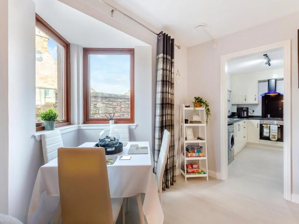 a kitchen and dining room with a table and a window at Failte Luxury Apartment in Inverness