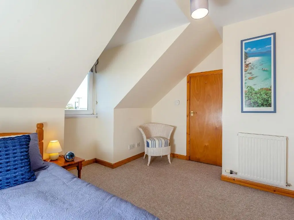 a bedroom with a bed and a chair at The Cherry Tree in Cawdor