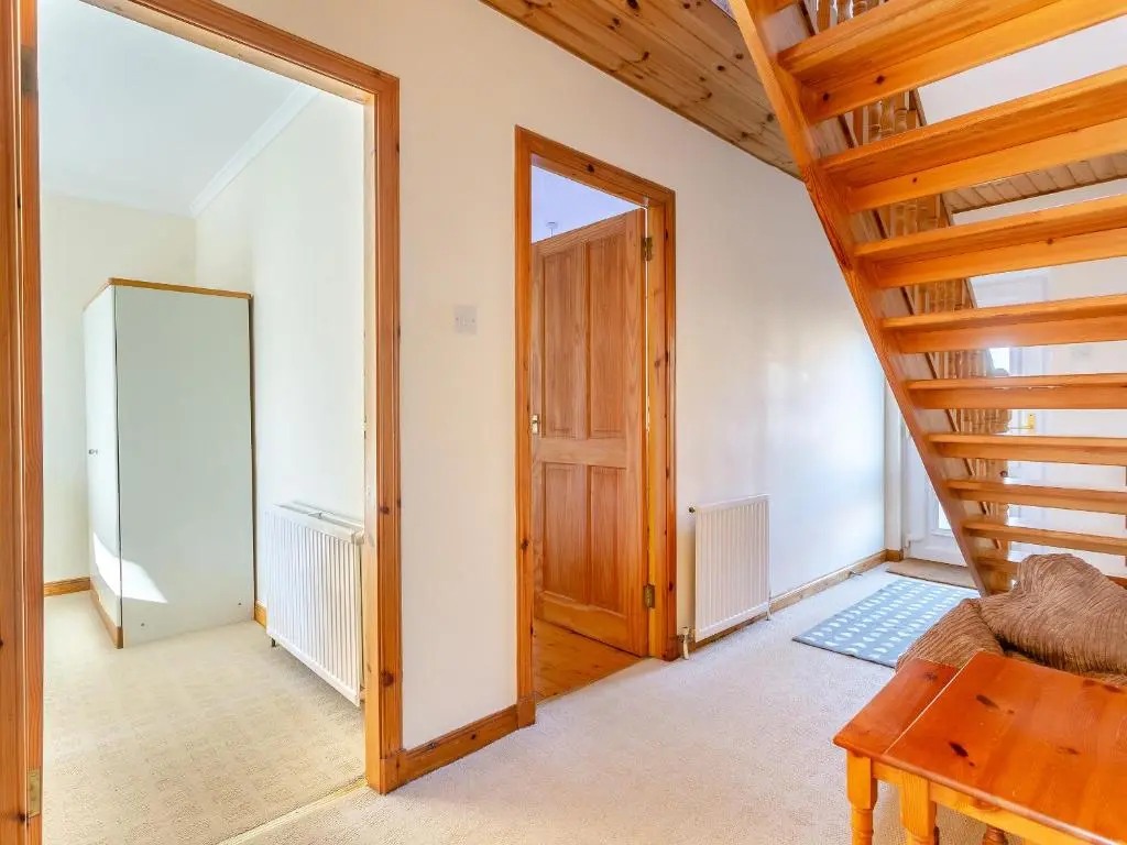 a room with a staircase and a wooden door at The Cherry Tree in Cawdor