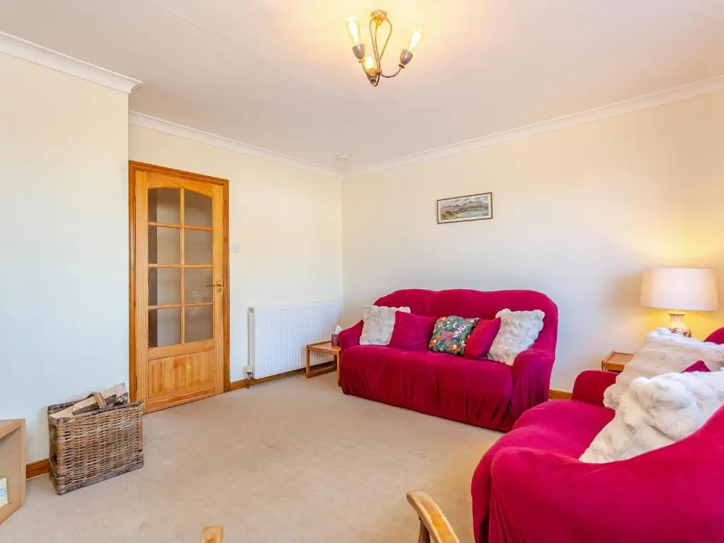 a living room with two red chairs and a red couch at The Cherry Tree in Cawdor