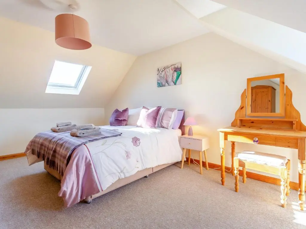 a bedroom with a bed and a dressing table at The Cherry Tree in Cawdor