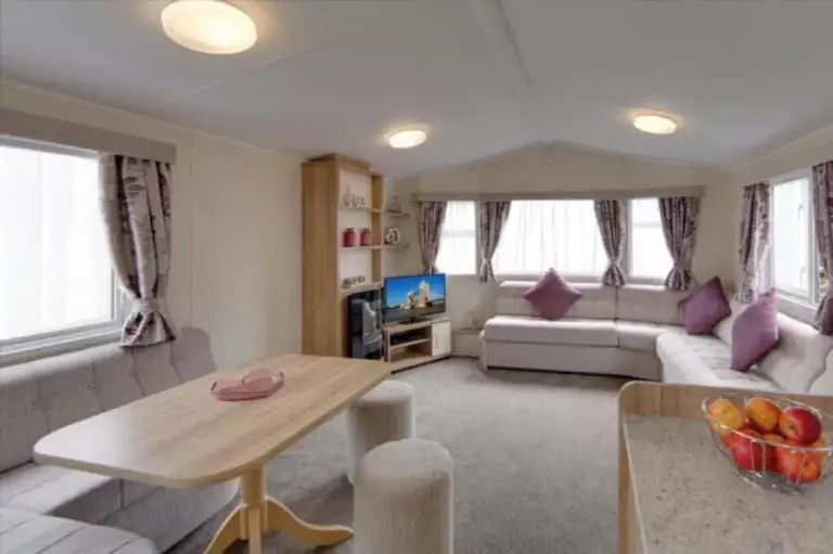 a living room with a couch and a table at Findhorn Bay - Mobile Holiday Homes in Findhorn