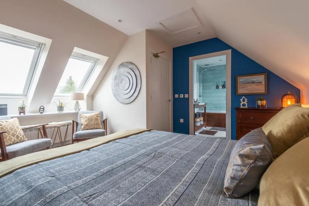 a bedroom with a large bed and blue walls at An I\u00f9bhrach in Inverness