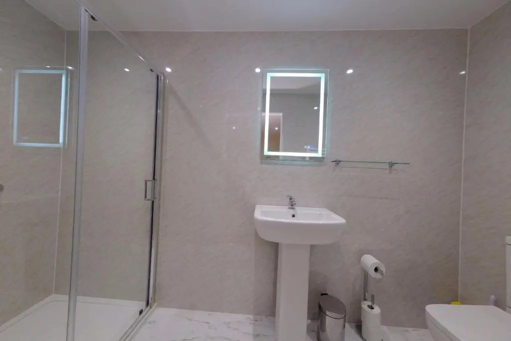 a bathroom with a sink and a glass shower at Suilven Cottage in Tain