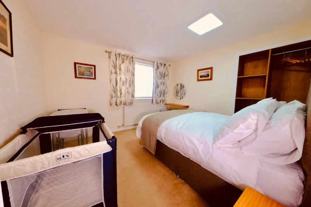 a hotel room with a bed and a window at Suilven Cottage in Tain