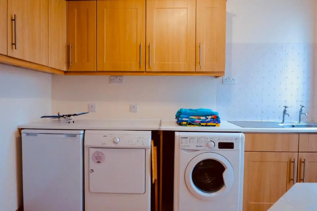 a kitchen with a washing machine and a sink at Suilven Cottage in Tain