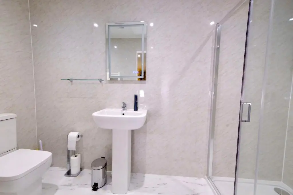 a white bathroom with a sink and a shower at Suilven Cottage in Tain