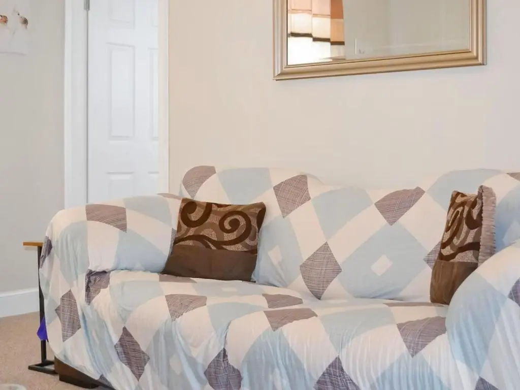 a couch in a living room with a mirror at Inverness Haven - with Parking and Garden in Dalneigh
