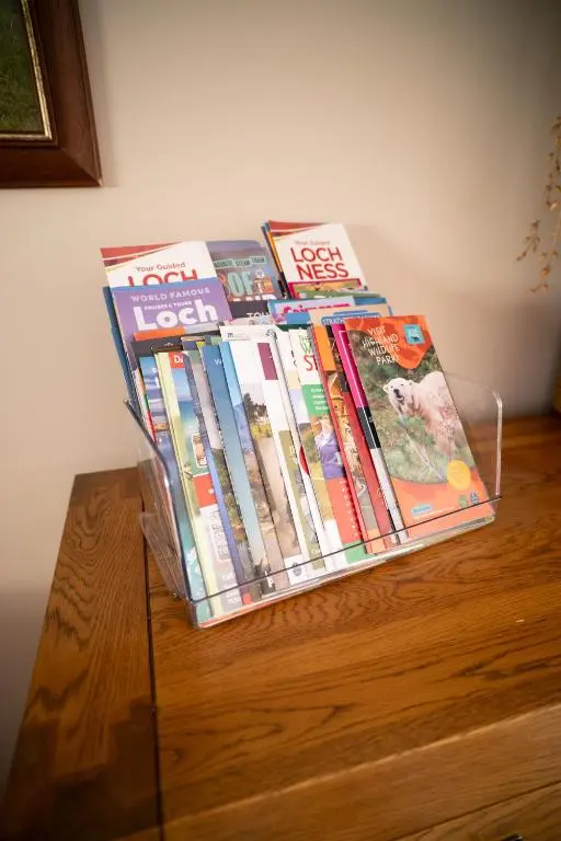 a pile of books sitting on top of a table at Royal Apartment in Inverness