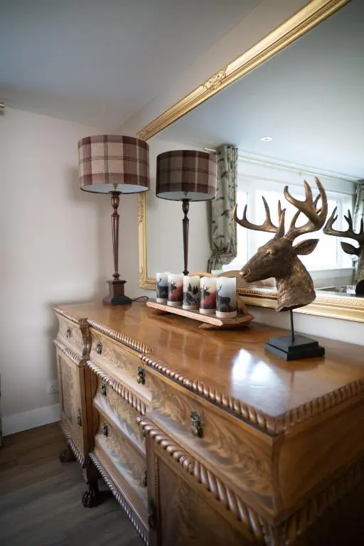a wooden dresser with two lamps on top of it at Royal Apartment in Inverness