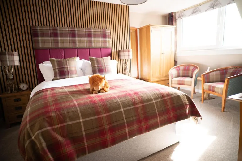 a cat sitting on a bed in a bedroom at Royal Apartment in Inverness