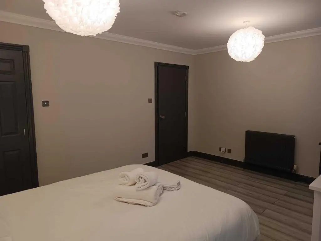 a bedroom with a bed with two towels on it at Woodgrove Holiday Homes in Inshes