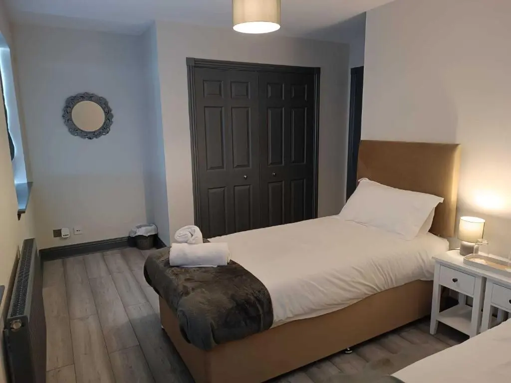 a bedroom with a large bed and a door at Woodgrove Holiday Homes in Inshes