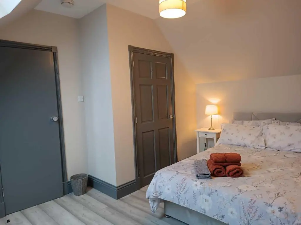 a bedroom with a bed with a brown door at Woodgrove Holiday Homes in Inshes