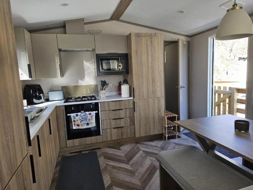 a kitchen with a stove and a dining table at Monash in Aviemore